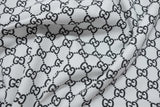 Black Gucci monogram print on white cotton fabric